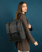 תיק גב טוקיו אפור מנומר על גב של דוגמנית, תיק טבעוני עם עיצוב פרקטי ומוקפד, מתאים לגבר ולאישה.