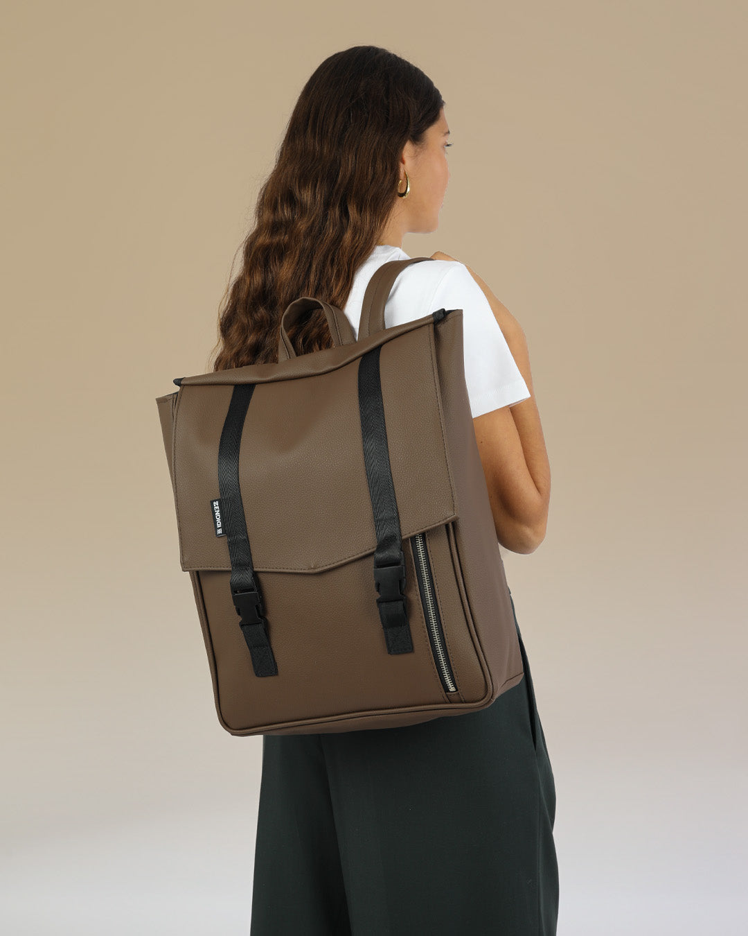 דוגמנית עם תיק גב טוקיו חום קלאסי מבית זנדיגי - תיק גב טבעוני למחשב נייד בעיצוב מינימליסטי ונקי, מושלם לסטודנטים ולהייטקיסטים.