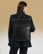 מילאנו שחור טוטם, תיק גב עם תא מרופד למחשב נייד 16 אינץ׳, על גבה של דוגמנית