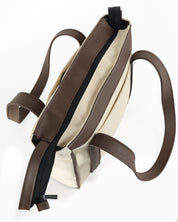 תיק מיני פלא בז׳ קנבס וחום כהה - מבט על עם חלוקה חכמה ותאים פנימיים. קומפקטי מבחוץ, מרווח מבפנים, מושלם ליום עמוס או חופשה.