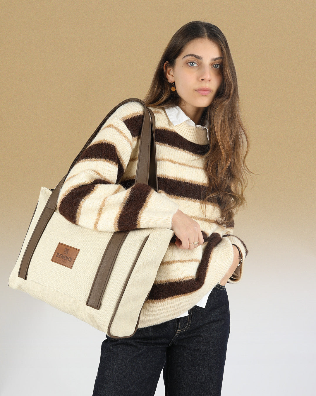 תיק צד ללפטופ 14״ מיני פלא בז׳ וחום מוצג על אישה, תיק צד לנשים ללימודים ולעבודה.