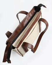 תיק מיני פלא בז׳ קנבס וחום כהה - מבט על עם חלוקה חכמה ותאים פנימיים. קומפקטי מבחוץ, מרווח מבפנים, מושלם ליום עמוס או חופשה.