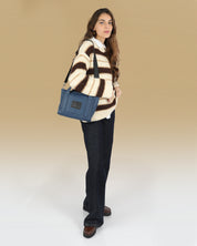 תיק קרוס באדי ויד מיקרו פלא כחול נייבי, תיק בינוני שמכיל המון, ניתן להחזקה ולנשיאה על כתף מוצג על דוגמנית שניתן לראות את כל גופה