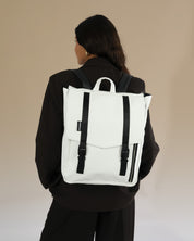 תיק גב טוקיו לבן קלאסי על גב של דוגמנית, תיק טבעוני עם עיצוב פרקטי ומוקפד, מתאים לגבר ולאישה.