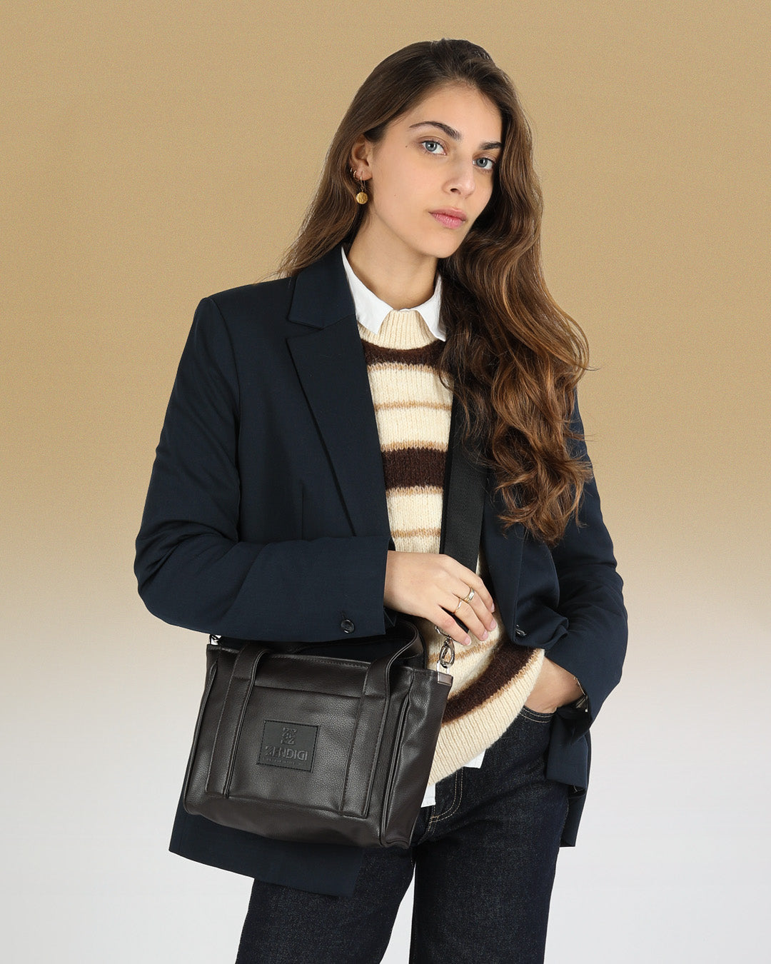 תיק קרוס באדי ויד מיקרו פלא קפה שחור, תיק קטן שמכיל המון, ניתן להחזקה ולנשיאה על כתף מוצג על דוגמנית באופן פרונטלי