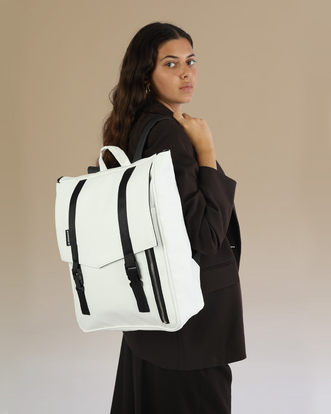 דוגמנית עם תיק גב טוקיו לבן קלאסי מבית זנדיגי - תיק גב טבעוני למחשב נייד בעיצוב מינימליסטי ונקי, מושלם לסטודנטים ולהייטקיסטים.